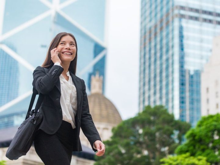 スーツを着た中国人女性がオフィス街を歩いているイメージ