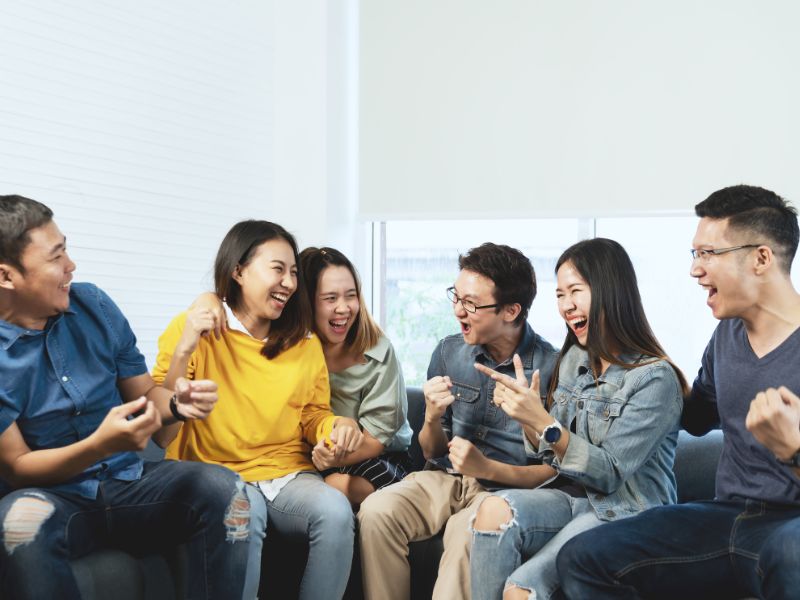 複数の中国人男女がソファーで談笑しているイメージ